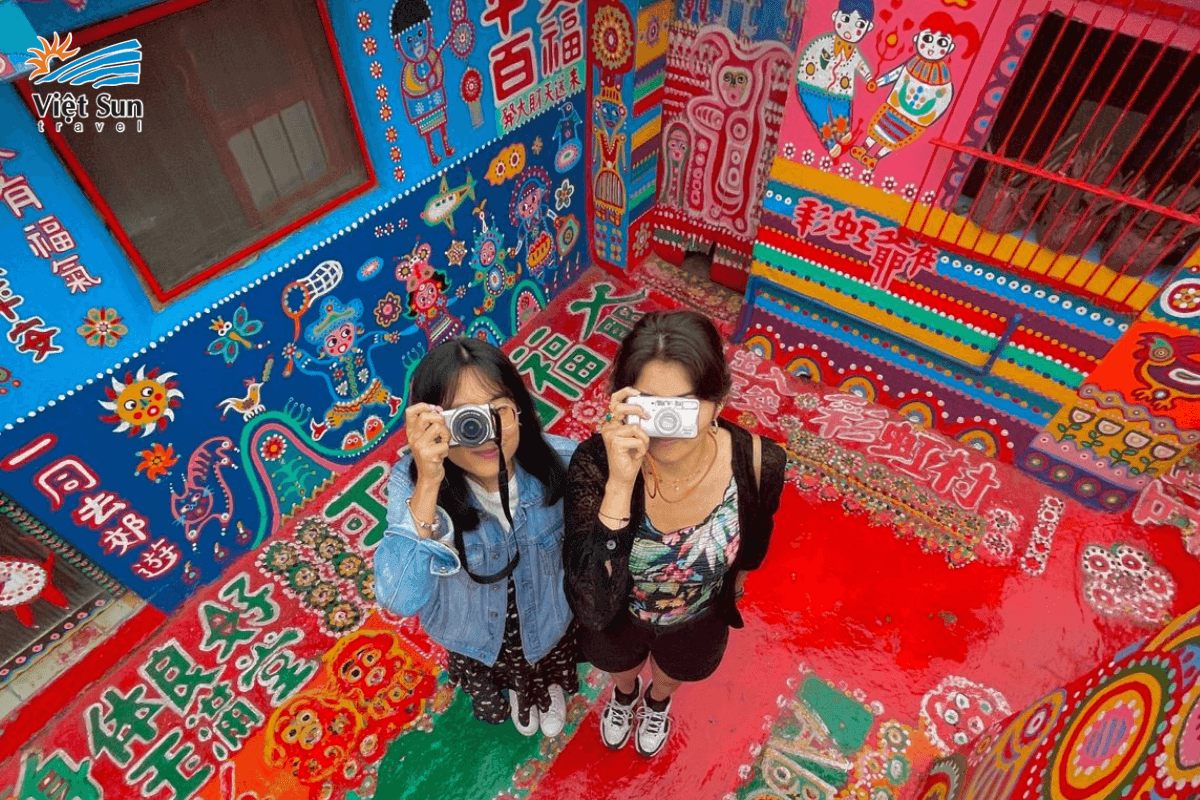 Du khách tạo dáng sống ảo bên tường cầu vồng ngộ nghĩnh.