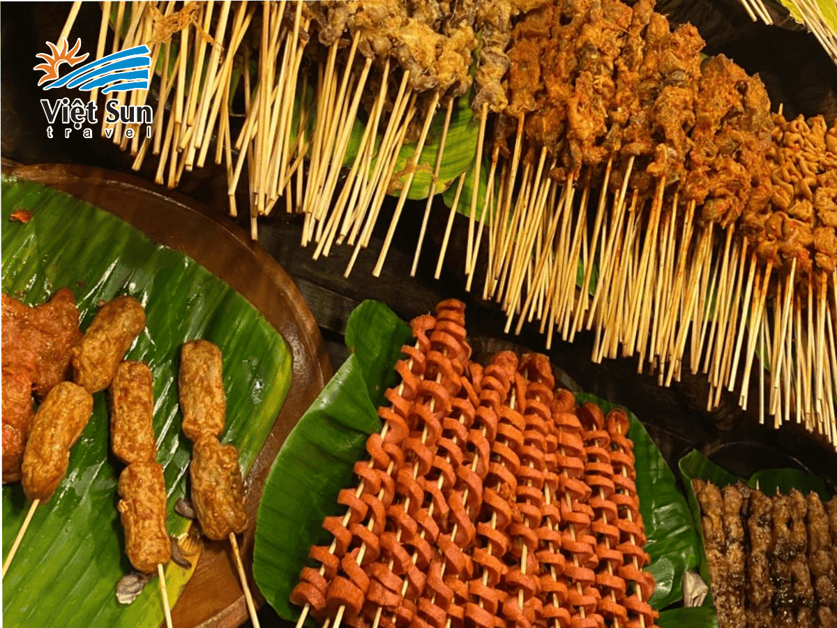 Xiên que đủ loại thịt và rau củ đang nướng trên than hồng.